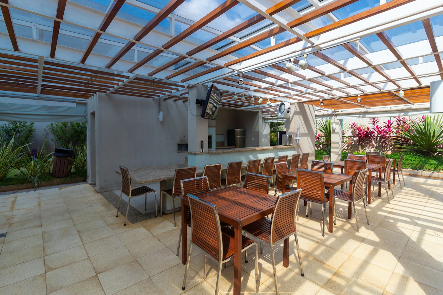 Outdoor patio with tables, chairs, and a barbecue area.