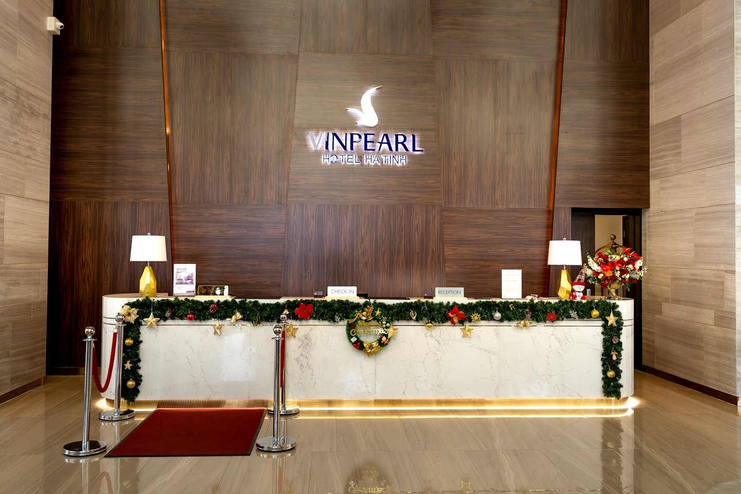 Empty hotel reception desk decorated with Christmas garlands and ornaments.